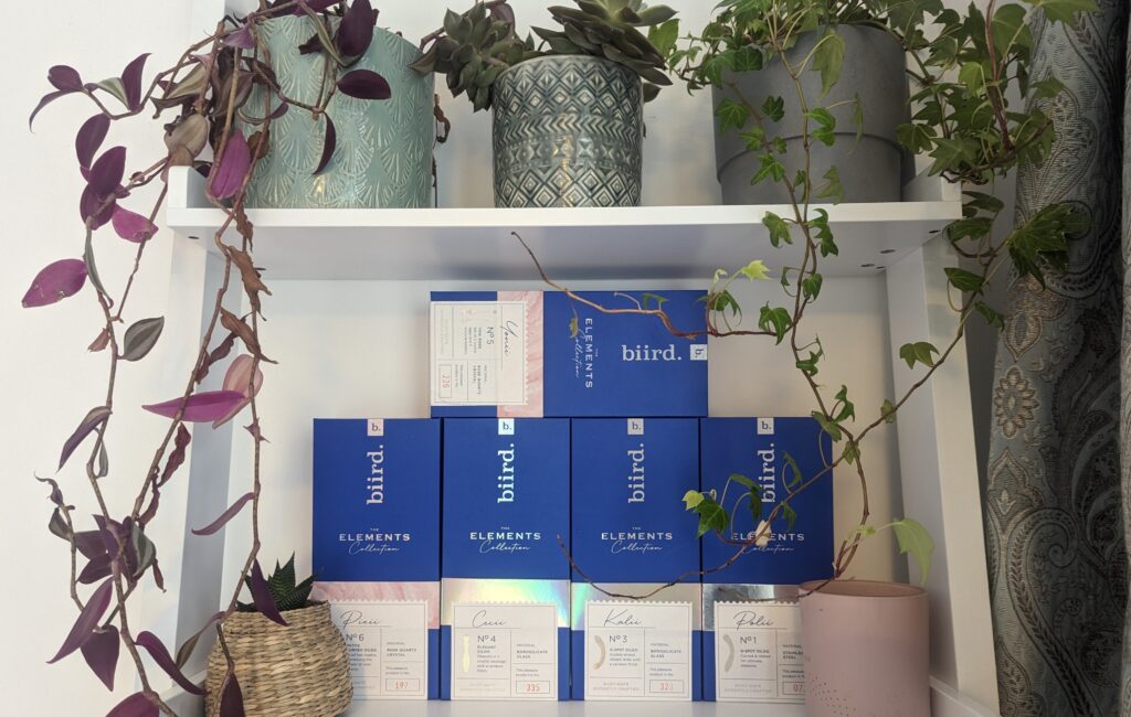 An editorial flatlay of design-led pleasure objects on patterned fabric.