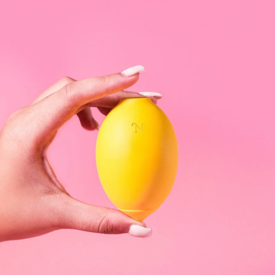 The Lem — a lemon-shaped air-pulse pleasure object in soft pastel yellow.