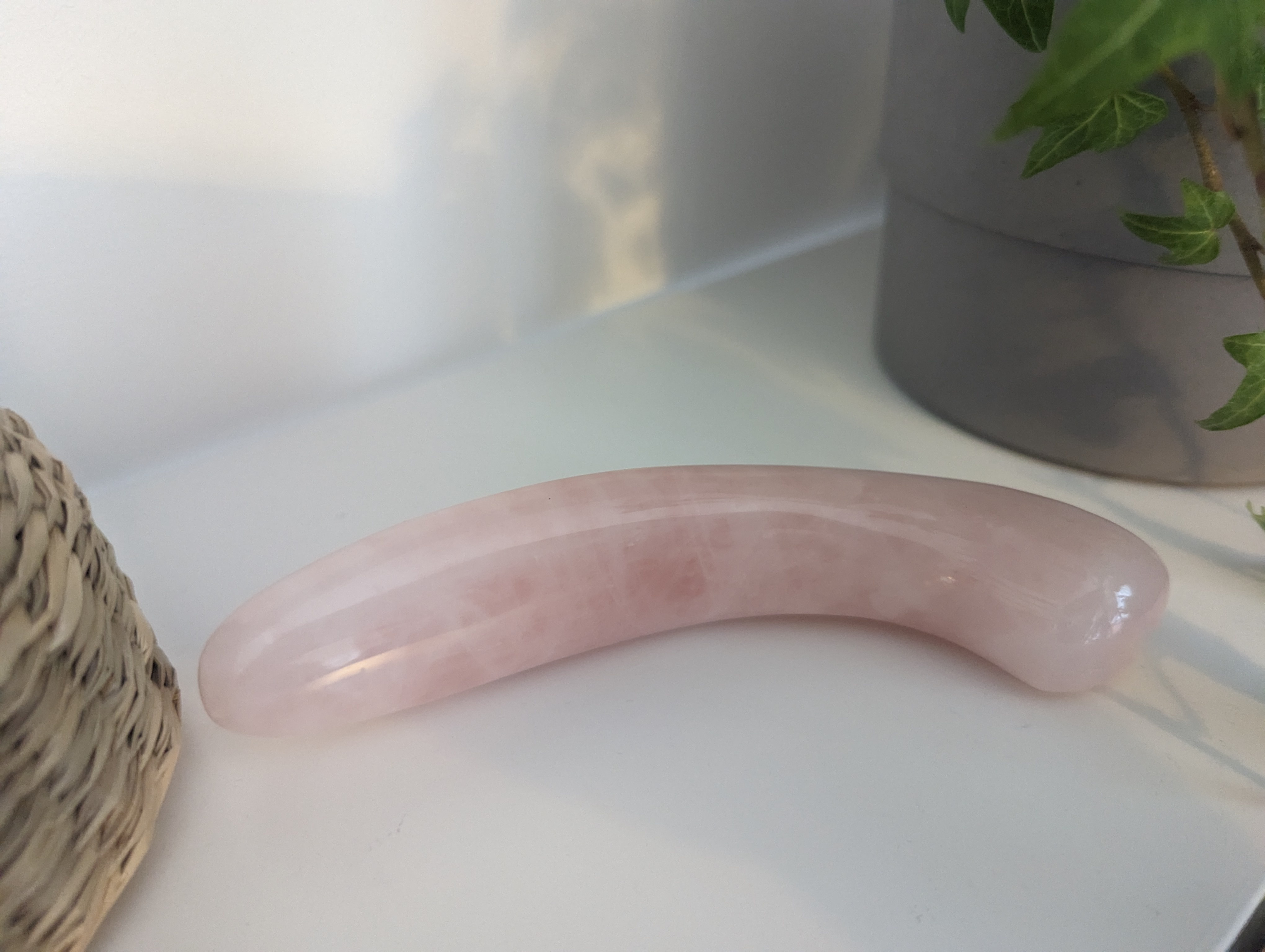 A row of hand-blown glass dildoes laid out for comparative review on neutral fabric.